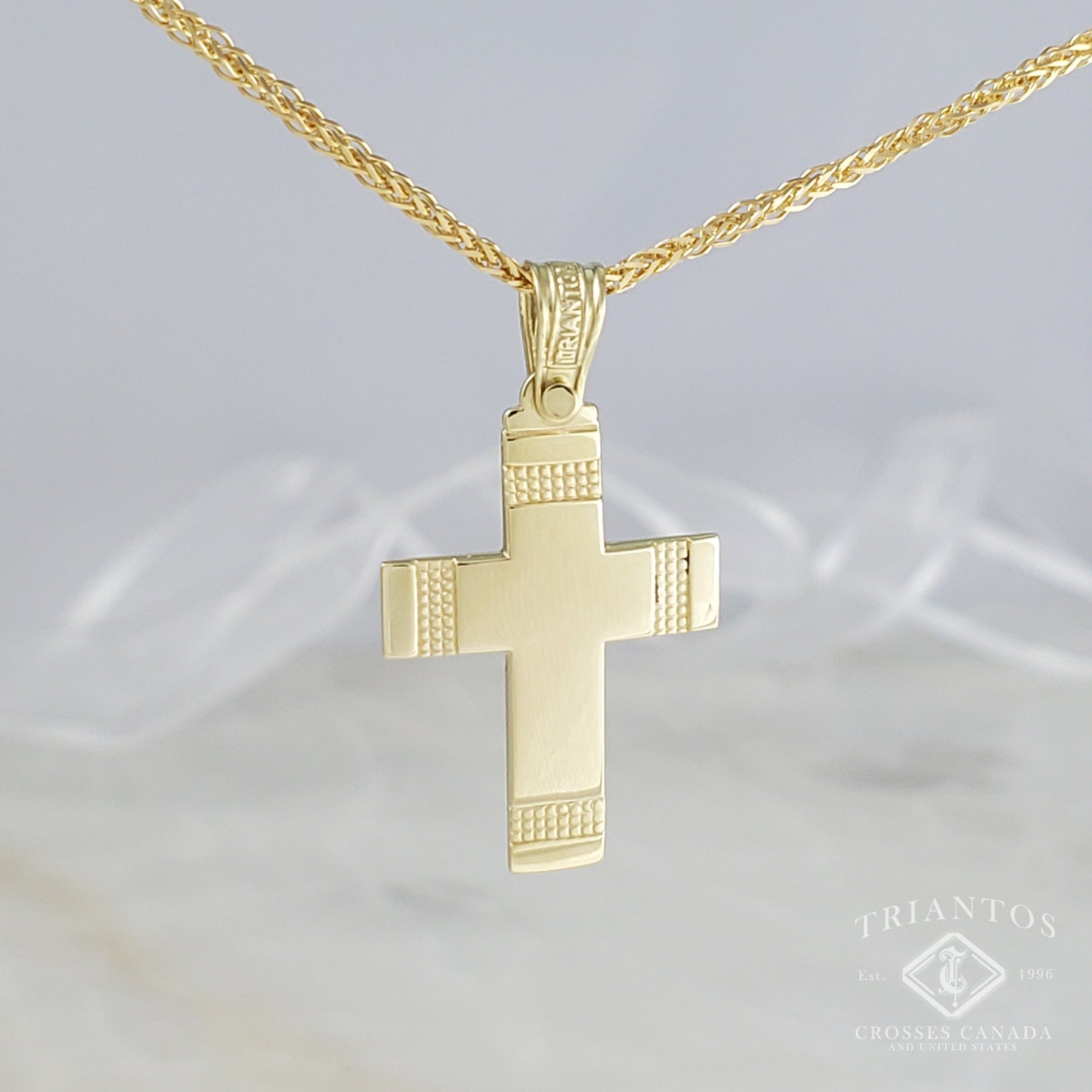 14k yellow gold triantos cross suspended on a gold chain