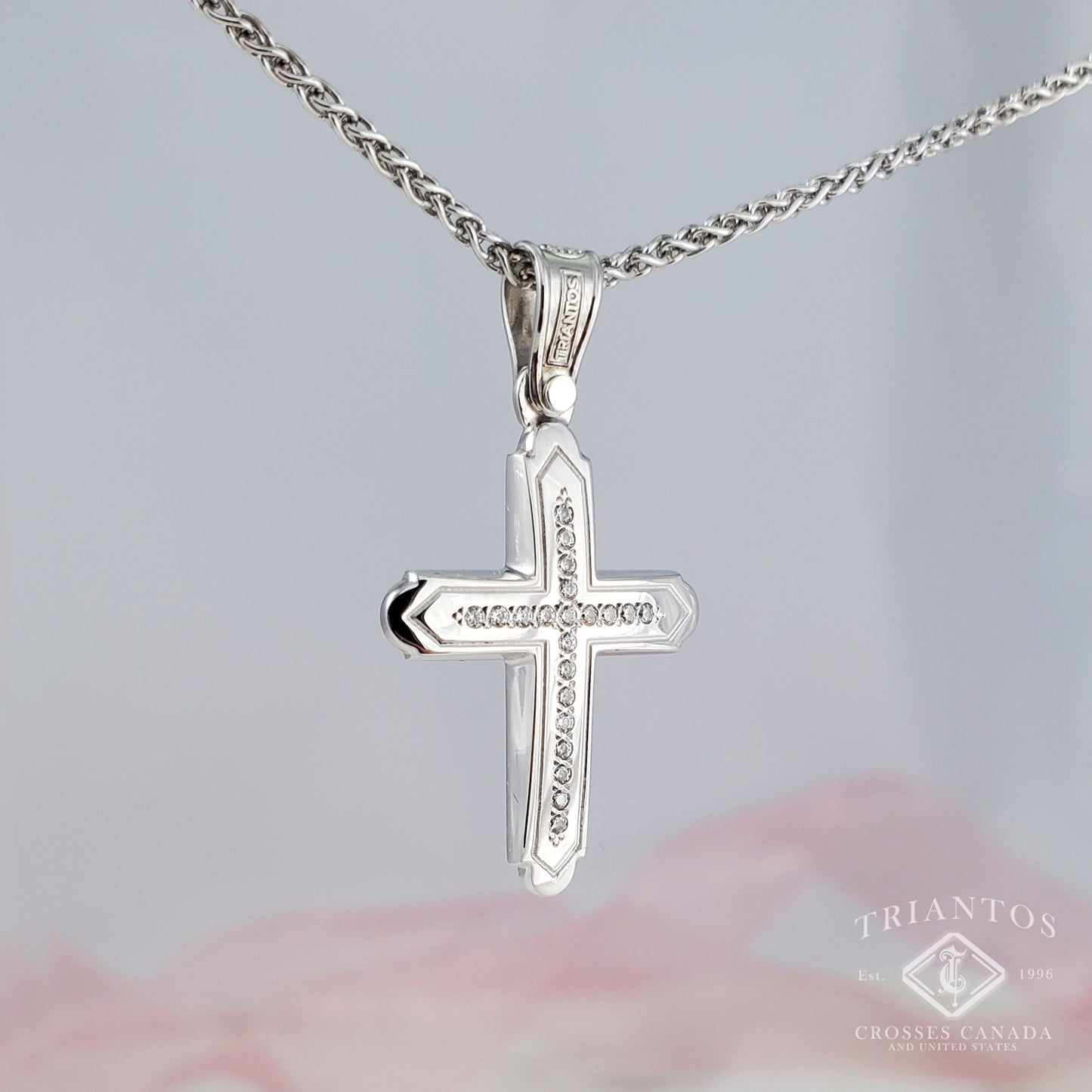 Woman's White gold cross pendant centered with 21 Sparkling cubic zirconia diamond-shaped stones and edged outline